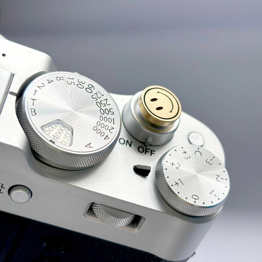 Close-up of engraved gold smile shutter button